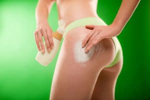 a woman applying cellulite cream