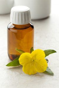 Bottle with Evening Primrose oil and fresh flower