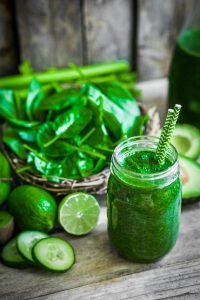 Green smoothie on rustic wooden background