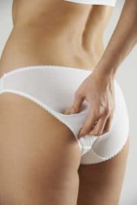 Woman In Underwear Pinching Buttocks