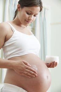 Pregnant Woman Moisturizing Belly with Stretch Mark Cream