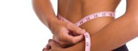 a slim woman measuring her waist