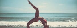 a woman doing yoga on the beach