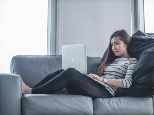 a woman on the couch with laptop