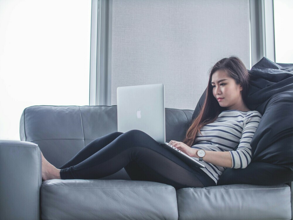 a woman on a couch with laptop