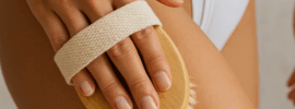 a woman dry brushing her legs